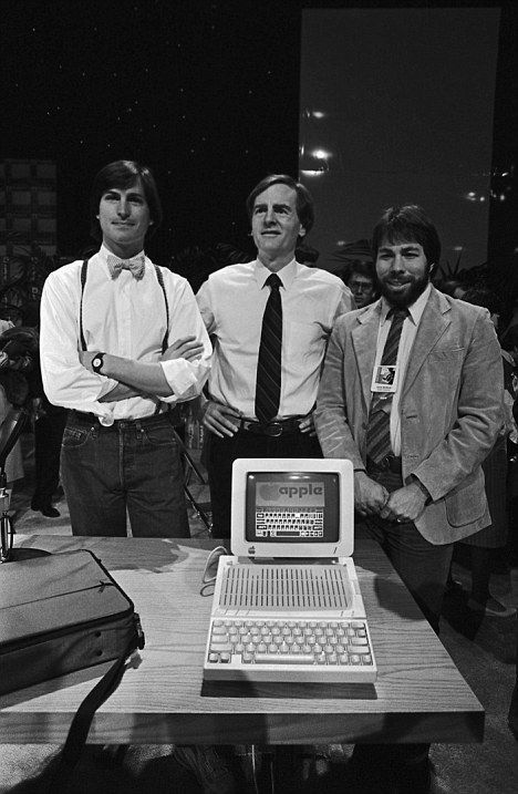 Президент Apple Джон Скалли (в центре), Стив Джобс (слева), Стивен Возняк (справа) и Macintosh Apple IIc, 1984 год