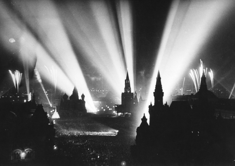 Салют Победы в Москве. Вид на Красную площадь. Праздничный салют начался 9 мая 1945 года в 22.00. Последовало тридцать залпов из тысячи орудий в небо, освещаемое прожекторами.